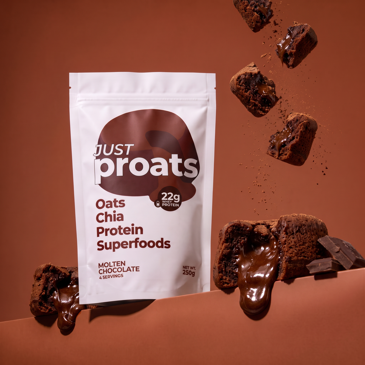 A stand-up pouch of Just Proats Oats Chia Protein Superfoods in Molten Chocolate flavor, shown on a warm brown background with floating and dripping chocolate pieces around it.