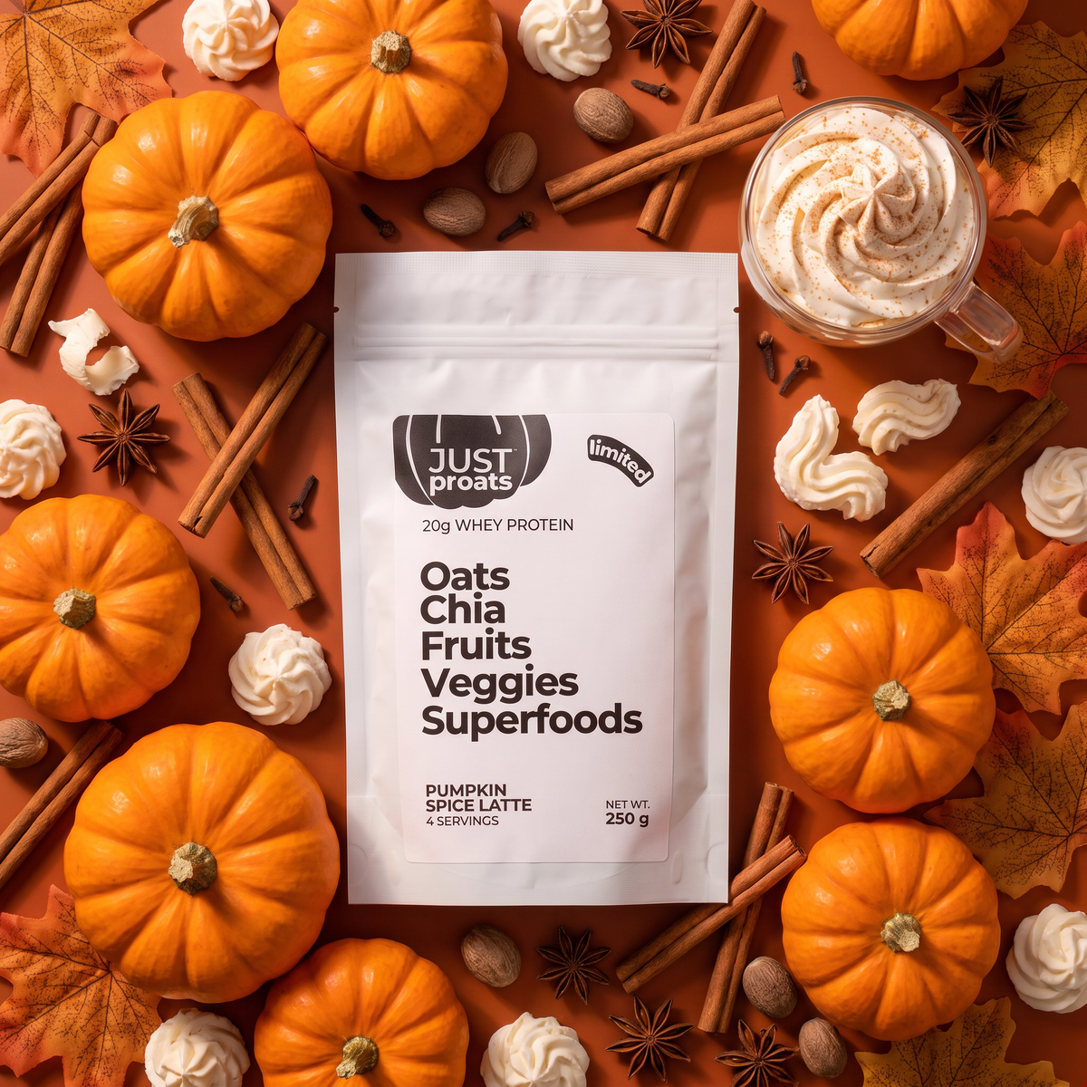 A stand-up pouch of Just Proats Oats Chia Fruits Veggies Superfoods in Pumpkin Spice Latte flavor, styled in a flat lay with orange pumpkins, cinnamon sticks, star anise, meringues, and a cup of whipped drink on an orange background.